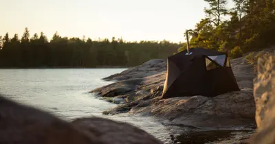 Bastu sauna tent set up on rocks by the water