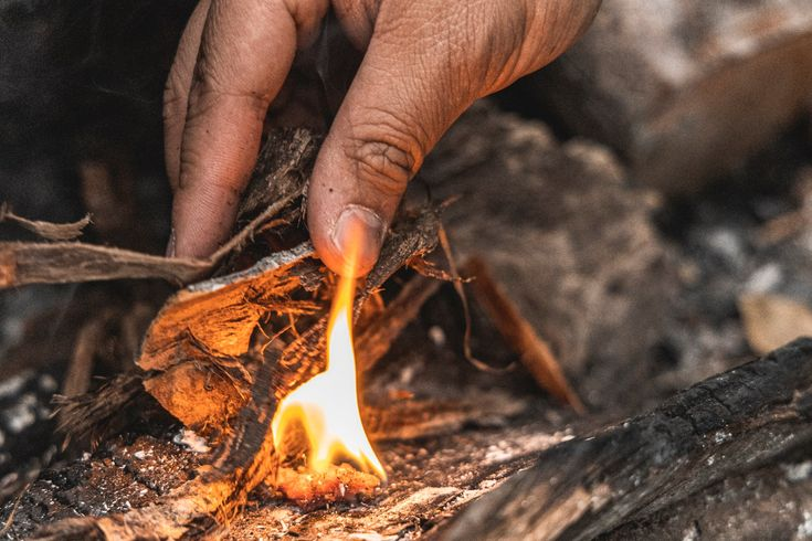 Hands lighting a small fire